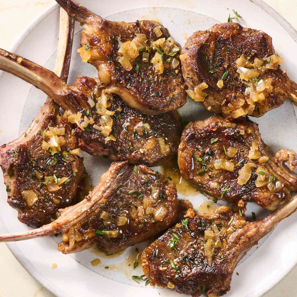 Grilled lamb chops seasoned with house spices and served with sides at Preva Kitchen Redford MI